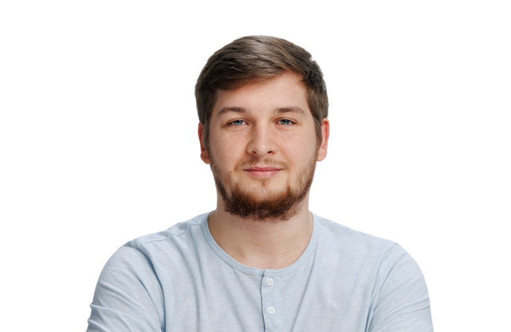Portrait of Łukasz Traczyk, back-end developer, a professional with a casual and approachable demeanor, wearing a light blue henley shirt. His relaxed, confident smile and neatly groomed beard convey a sense of friendliness and expertise, suitable for an author or staff profile photo.