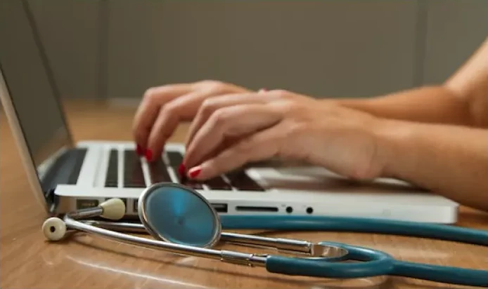 A stethoscope and laptop on a table in a doctor's office
