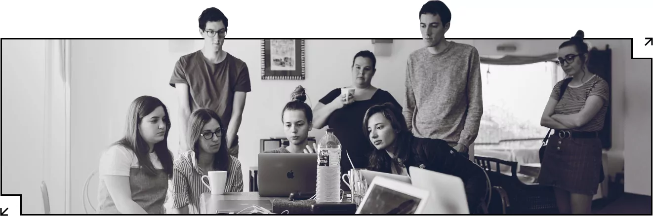 People engaged in teamwork, sitting around the table together.